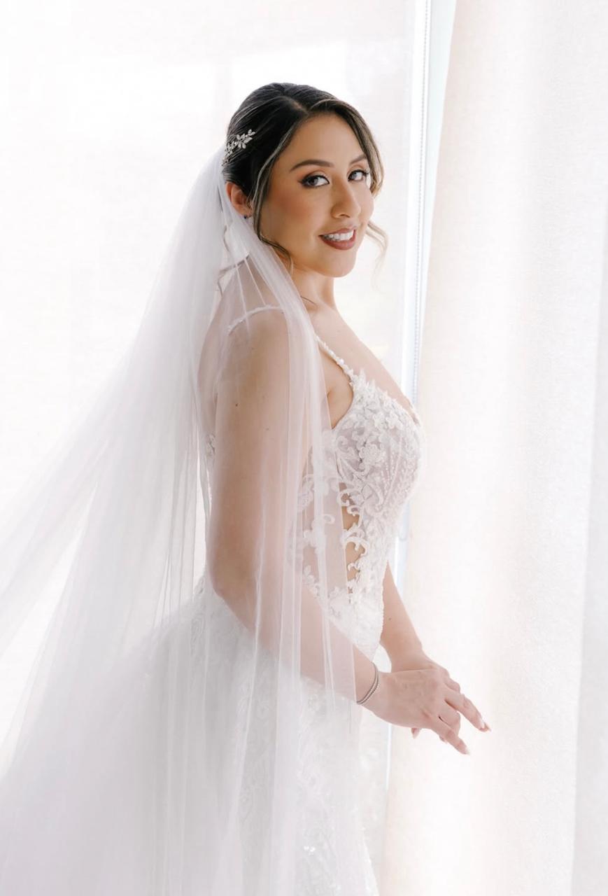 Novia con velo junto a ventana